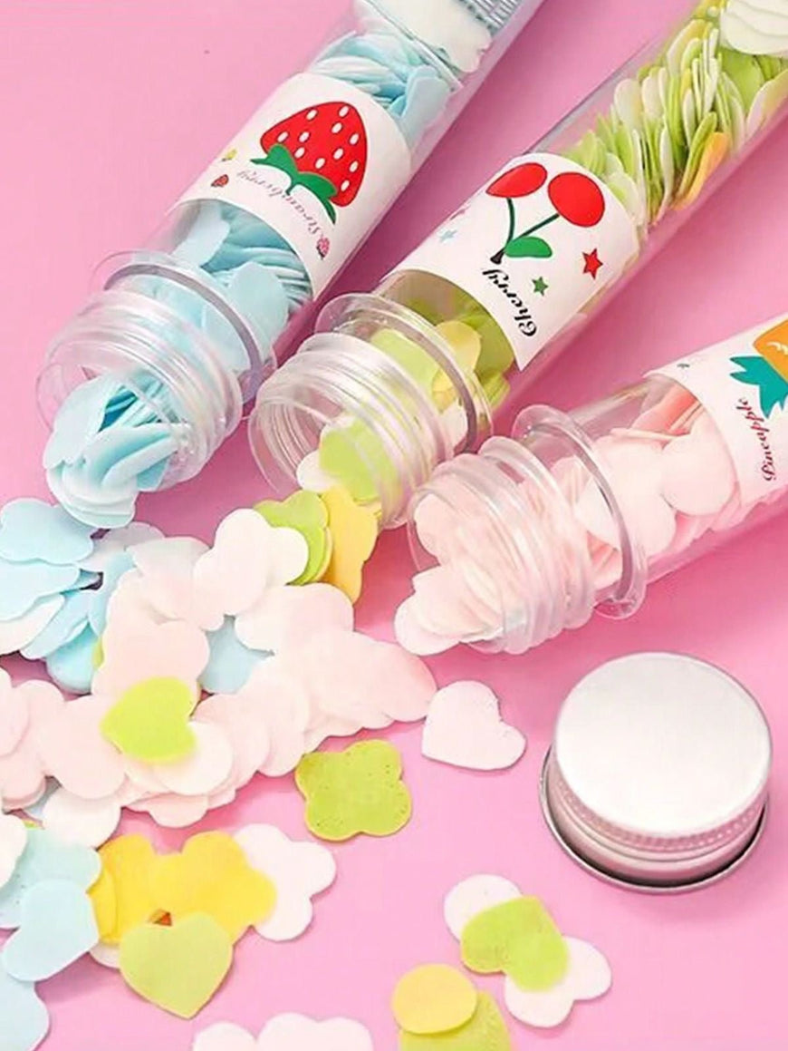 Colorful paper soap sheets spilling out of small transparent bottles on a pink background for portable hand hygiene