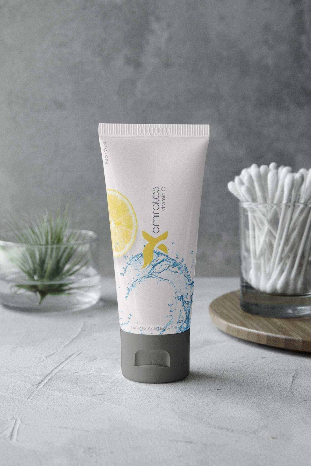 CreamXemirates Deep Cleansing Facewash in a white plastic tube with a dark grey cap and blue splash and yellow citrus graphics