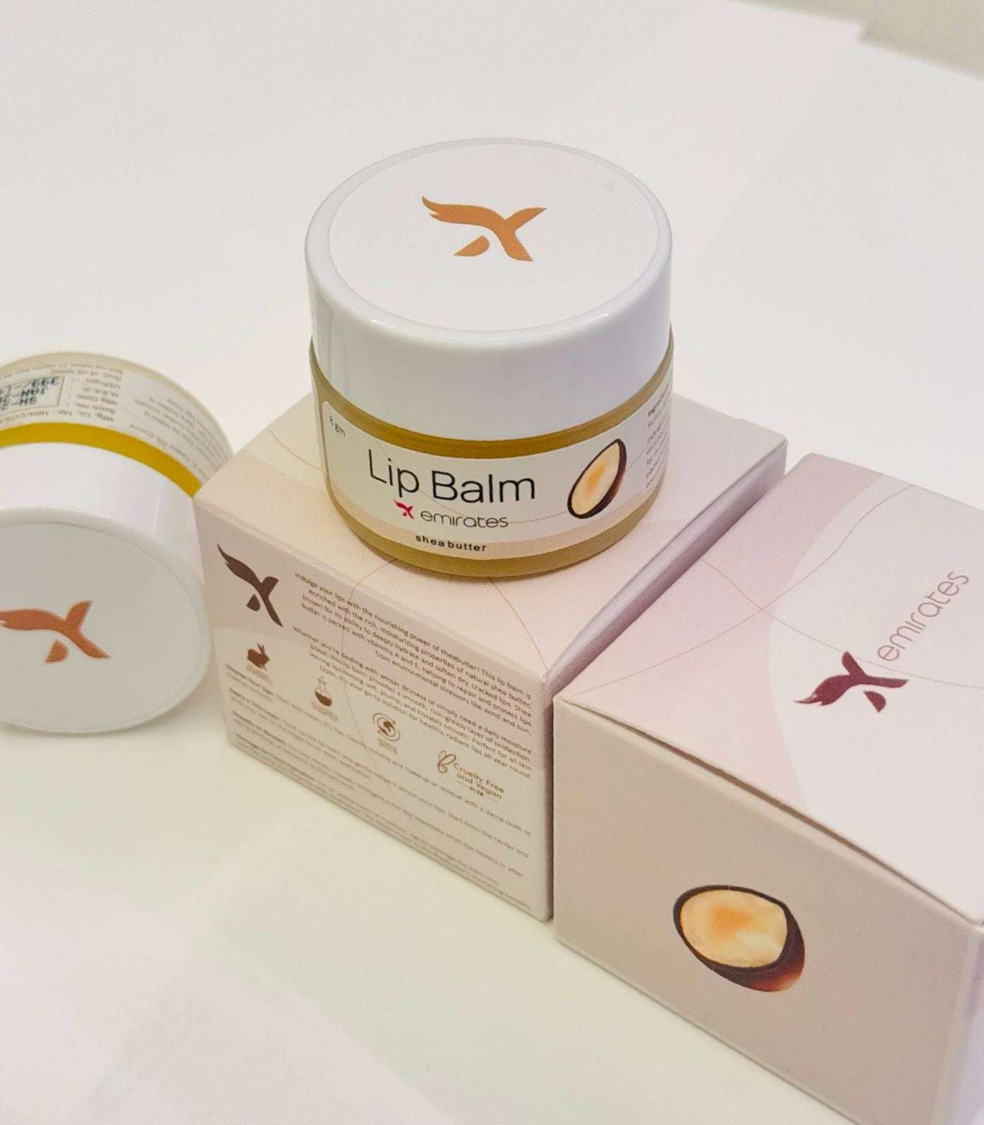 X Emirates Lip Balm jar with packaging featuring shea butter, moisturizing and nourishing lip care product